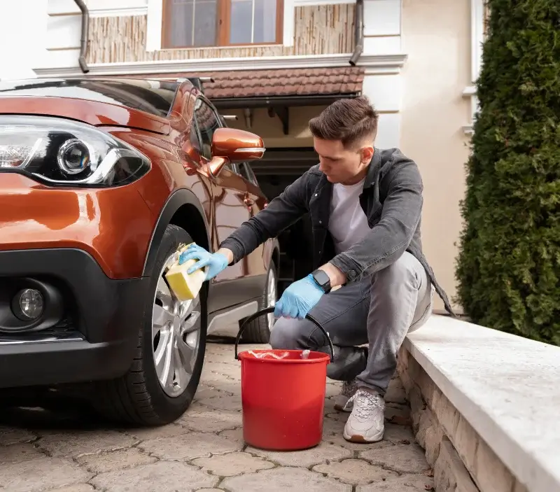 Lavage auto à domicile Puiseux-Pontoise : professionnel intervenant sur un véhicule